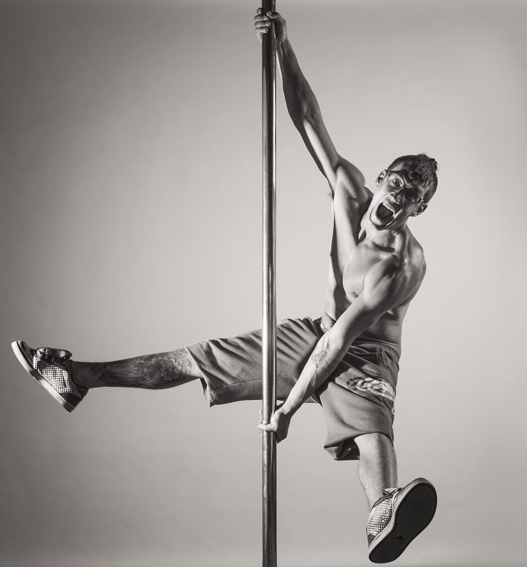 Pole dancing man in shorts at a photoshoot