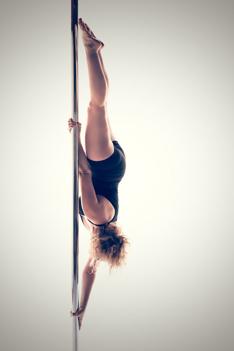 Advanced Pole move known as twisty grip handspring.